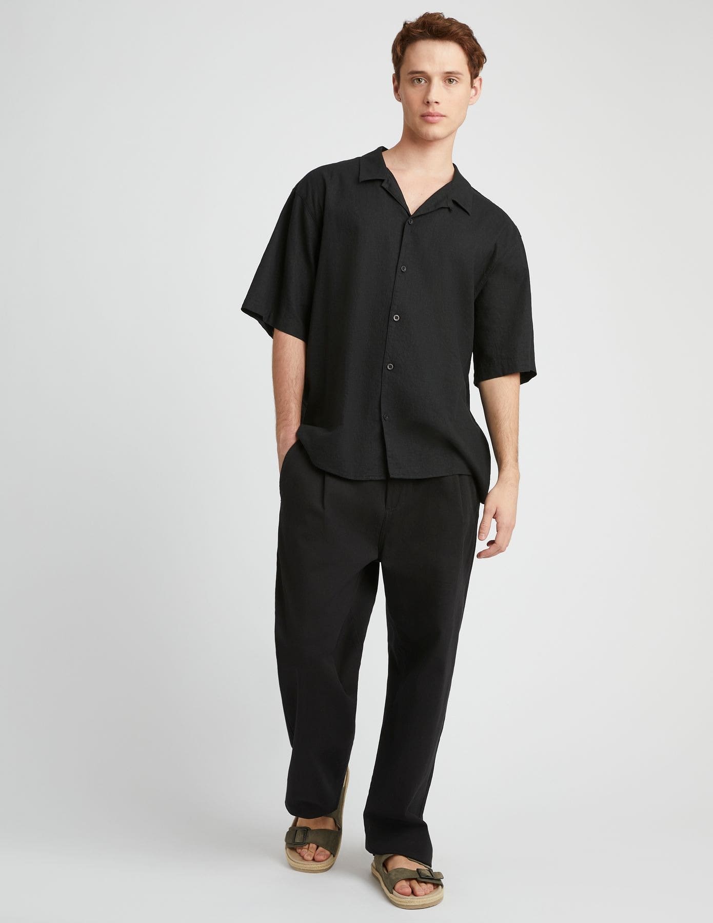 Look minimaliste élégant en total black avec chemisette noire, pantalon large noir et sandales en cuir