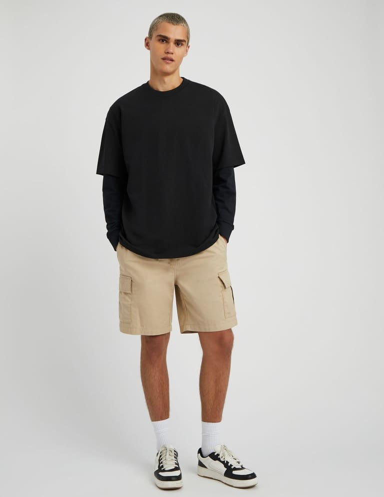 Polo en maille noir avec pantalon wide leg lilas délavé et sneakers à reflets argentés