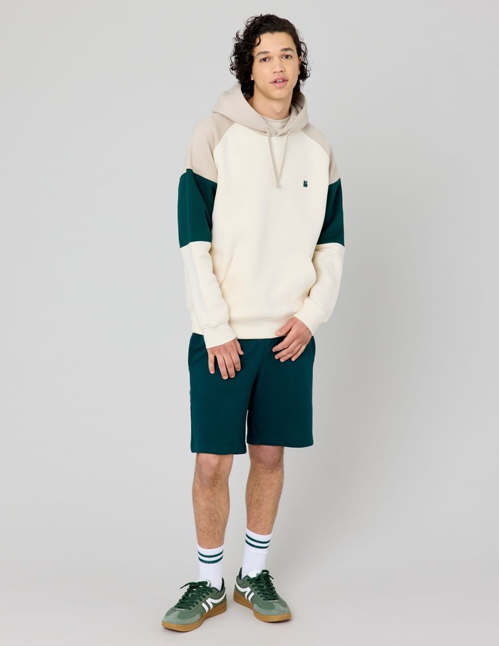 Look streetwear homme avec sweat à capuche bleu ciel, casquette denim et pantalon large gris