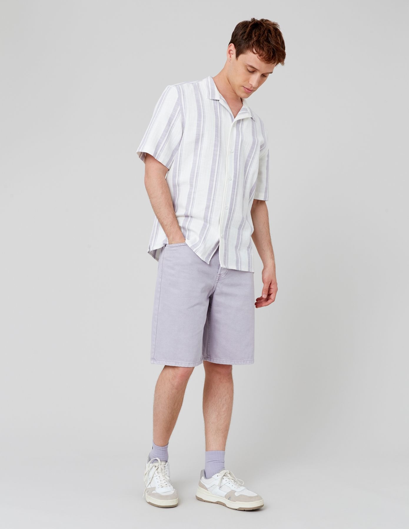 Style casual urbain avec bermuda gris-lilas, chemise à rayures et baskets blanches