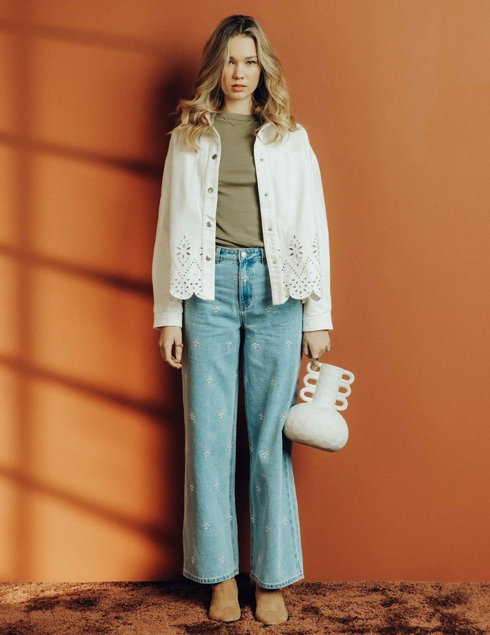 Co-ord denim écru brodé de motifs floraux dorés composé d'un jean barrel wide leg et d'une veste assortie, porté avec une blouse blanche et des bottines noires