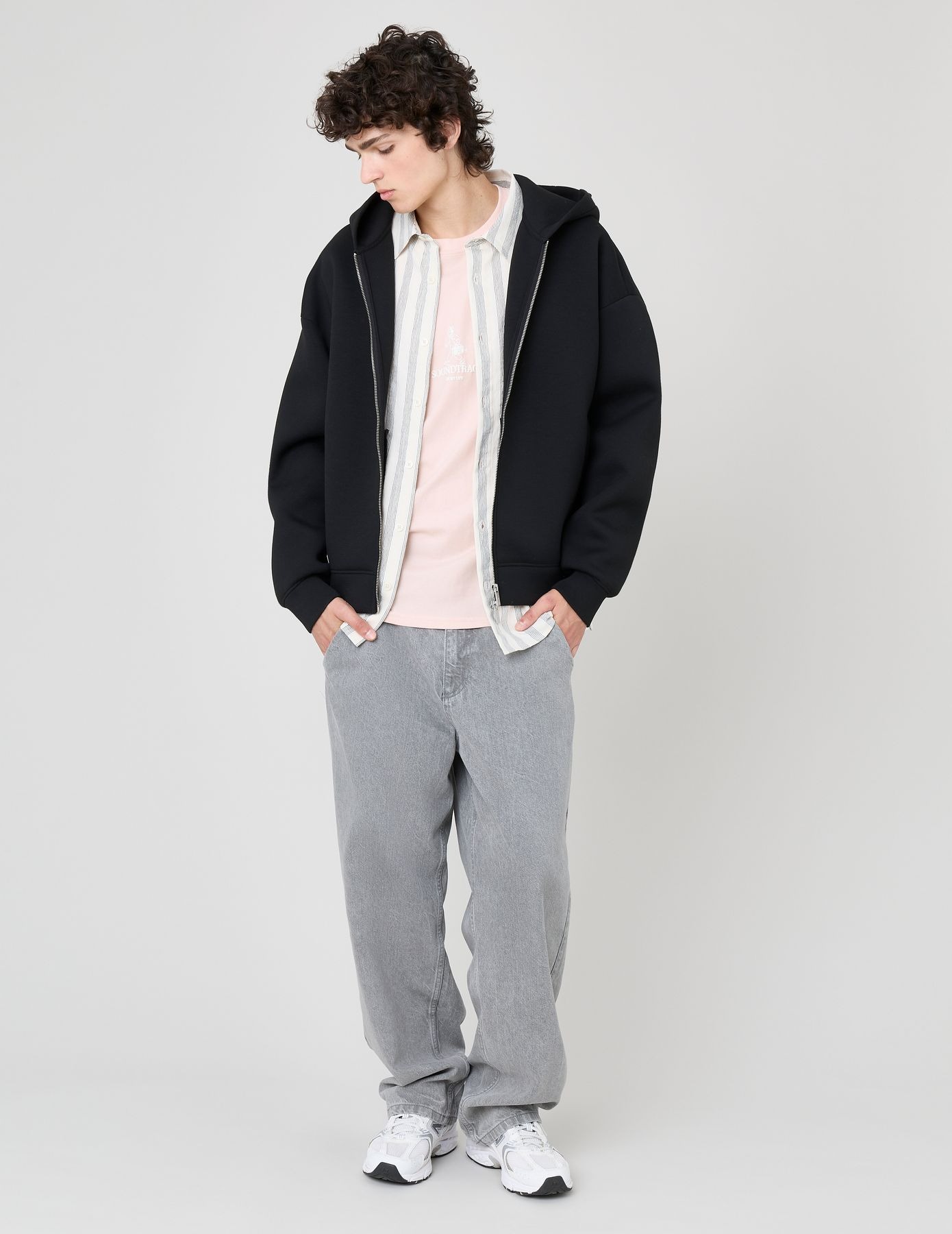 Look layering avec hoodie noir sur chemise à rayures et t-shirt rose