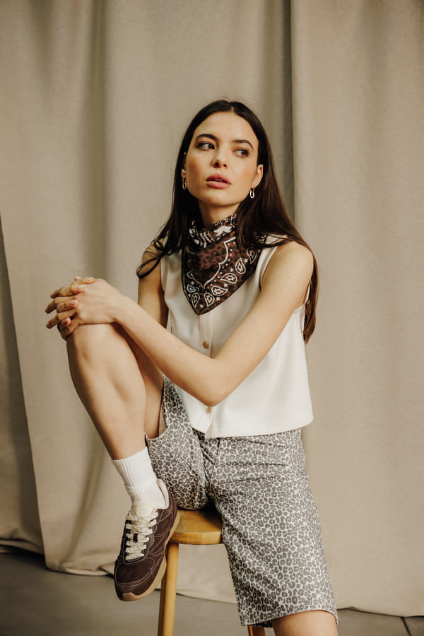 Look casual urbain avec bermuda léopard gris, débardeur blanc et baskets rétro