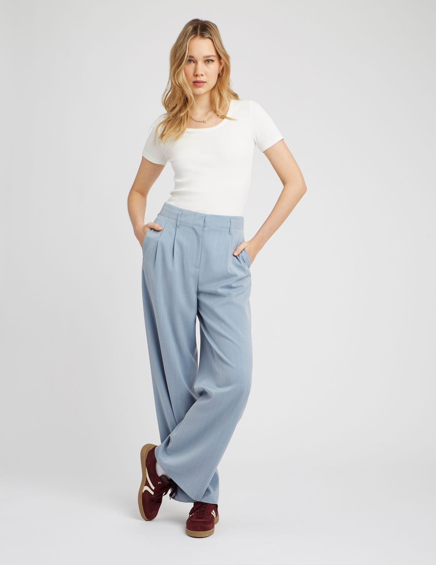 Look casual élégant avec t-shirt blanc, pantalon large bleu ciel et baskets bordeaux