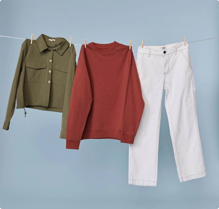 Veste, sweat et pantalon qui sèchent sur un fil à linge