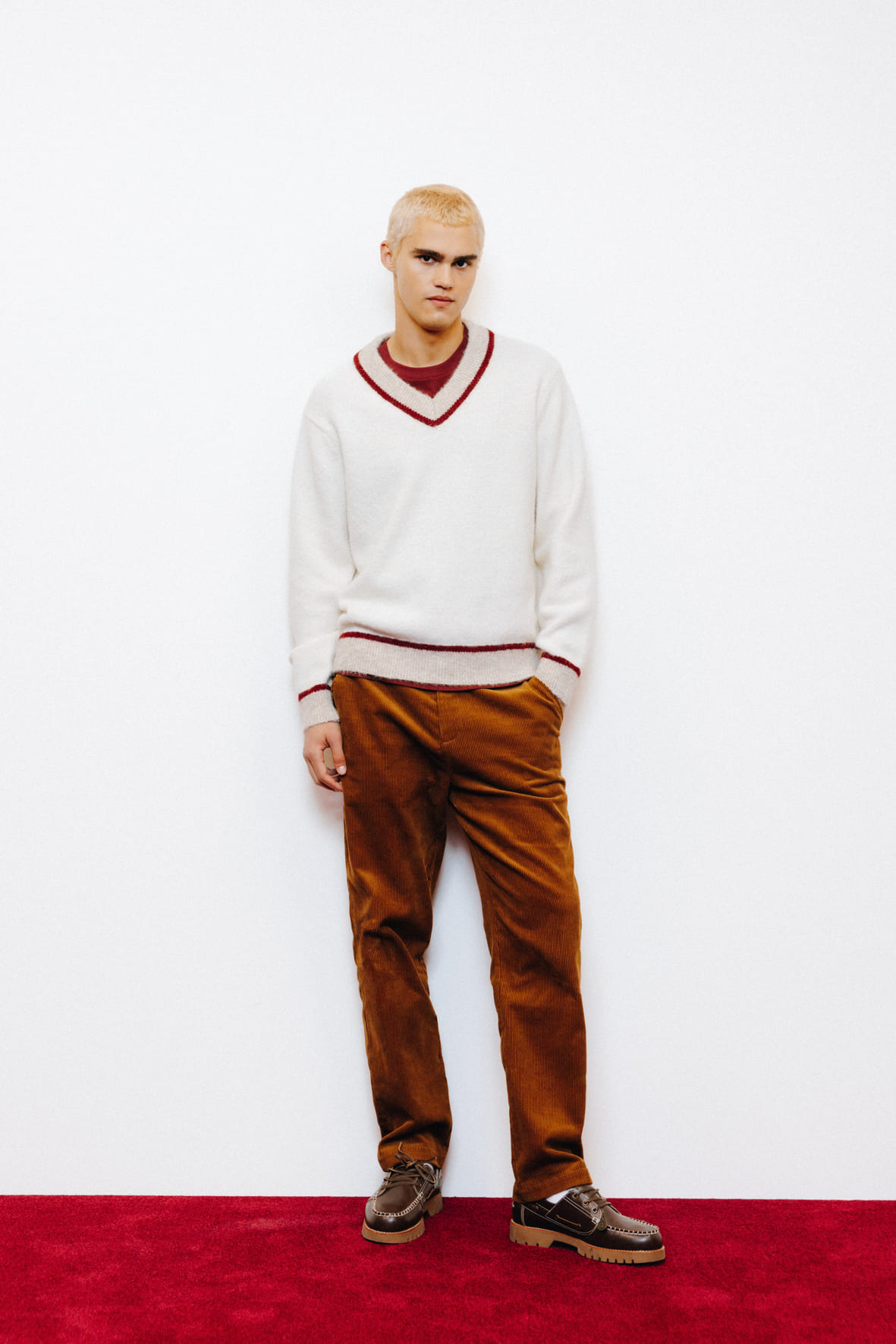 Look classique avec pull col V blanc à liseré bordeaux sur t-shirt et pantalon velours marron