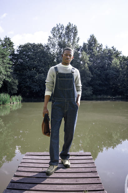 Look workwear original avec pull rayé sous salopette en jean