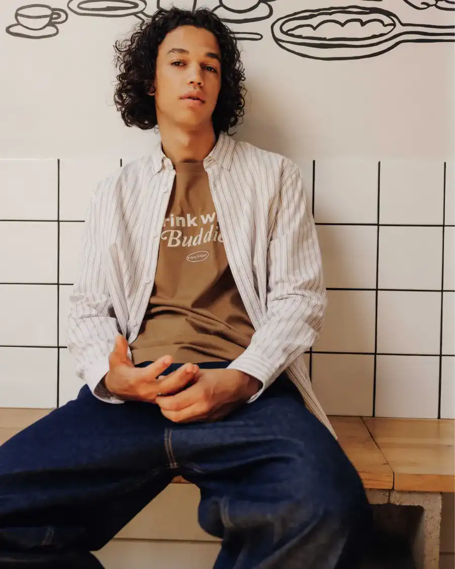 Chemise oxford rayée portée avec un t-shirt imprimé et brodé et un jean skater brut