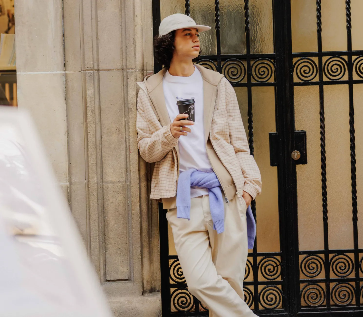 Blouson léger à capuche porté avec un sweat zippé, un t-shirt imprimé devant/dos et un pantalon jogger relaxed