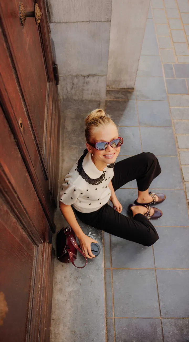 Gilet jacquard à pois porté avec un pantalon kick flare et un sac seau bandoulière à chaîne