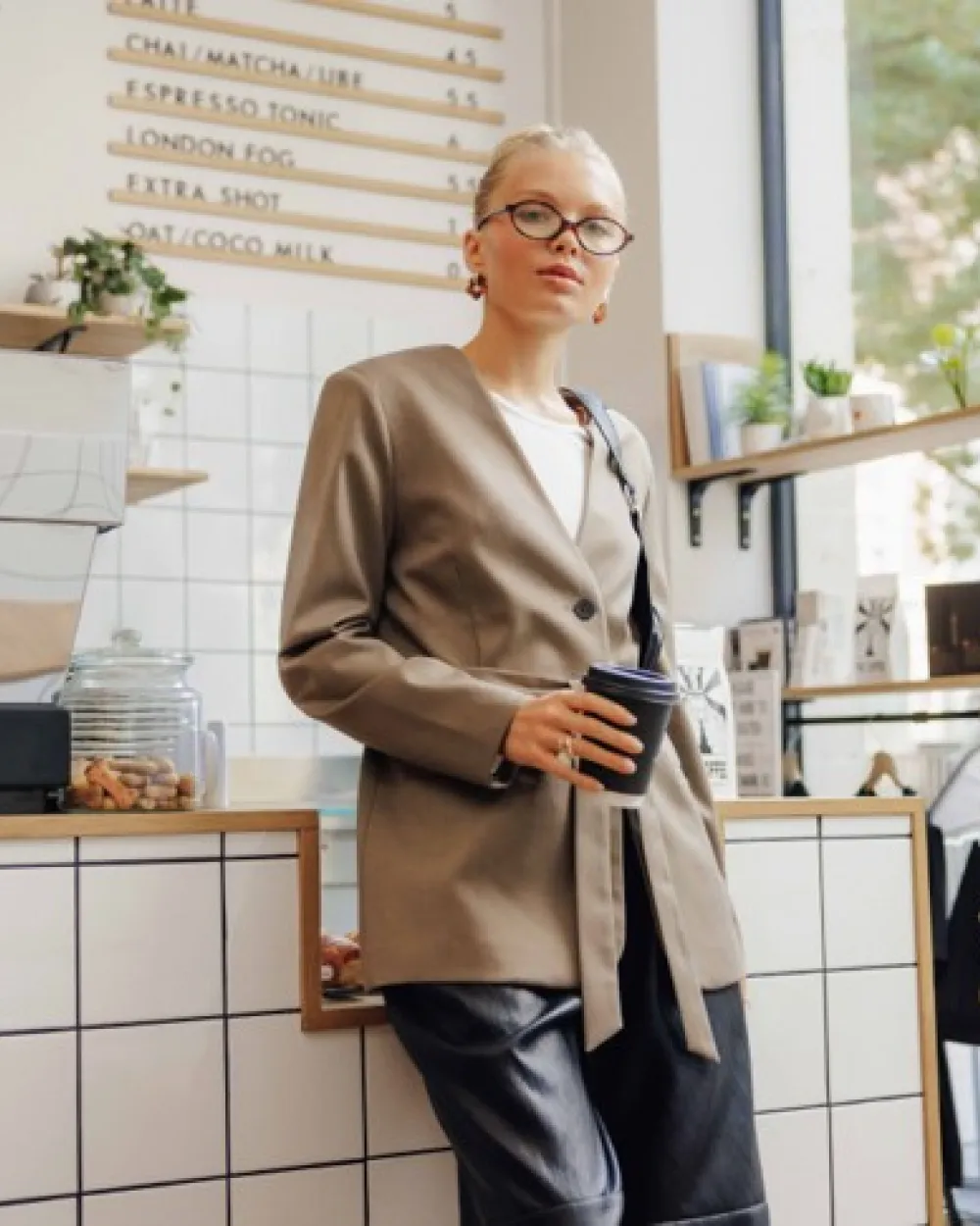 Blazer ceinturé porté avec un t-shirt manches longues côtelé et un pantalon en tissu enduit à pinces