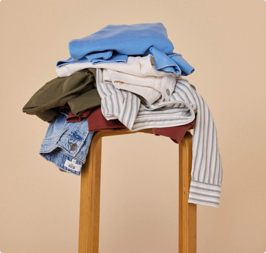 Pile de vêtements posée sur un tabouret en bois