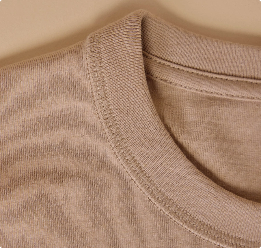 Détail de l’encolure d’un t-shirt en maille beige
